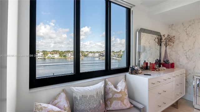 bedroom featuring crown molding and a water view