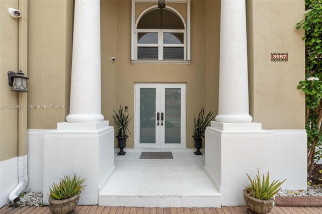 doorway to property featuring covered porch and french doors