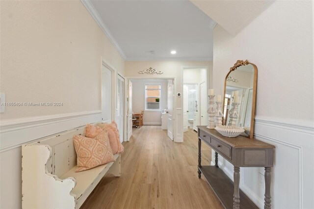 hall featuring light hardwood / wood-style floors and ornamental molding