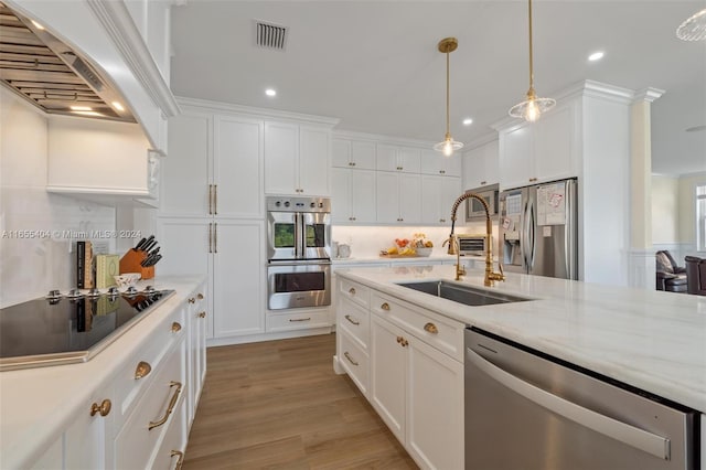 kitchen featuring white cabinets, pendant lighting, sink, and appliances with stainless steel finishes