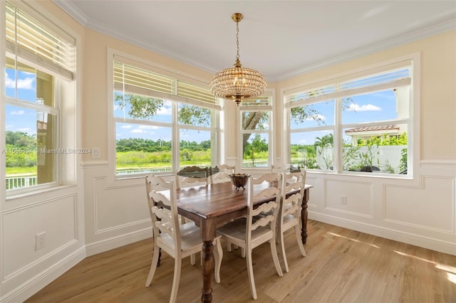 dining room with light hardwood / wood-style flooring, a chandelier, and ornamental molding