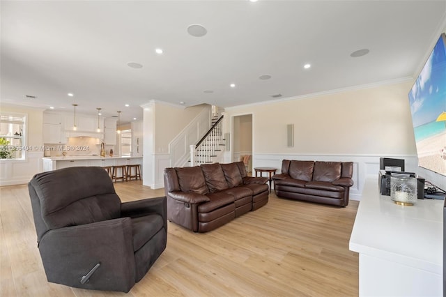 living room featuring light hardwood / wood-style flooring and ornamental molding