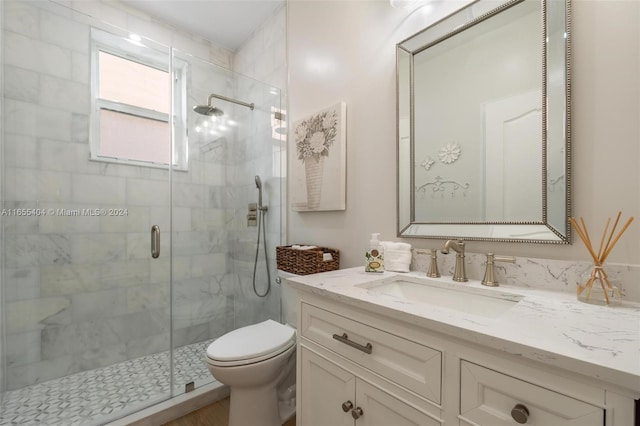 bathroom with vanity, toilet, and a shower with door