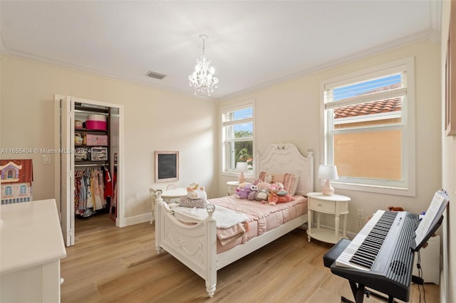 bedroom featuring crown molding, a closet, a chandelier, and light wood-type flooring