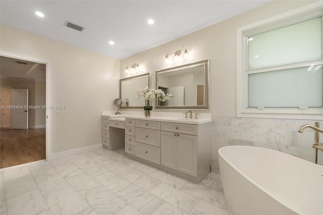 bathroom featuring vanity, a tub, and tile walls