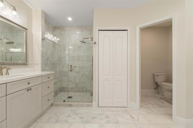 bathroom with vanity, toilet, and a shower with door