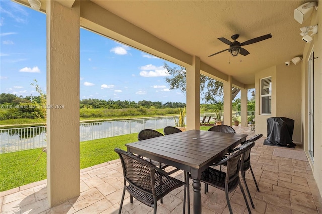 view of patio / terrace featuring a grill, ceiling fan, and a water view