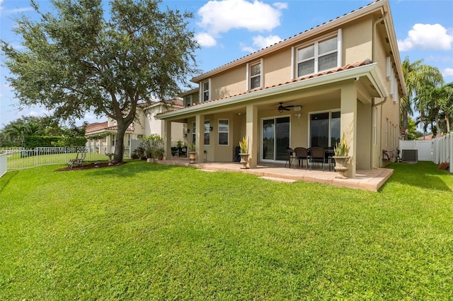 rear view of house with ceiling fan, a yard, a patio, and central AC unit