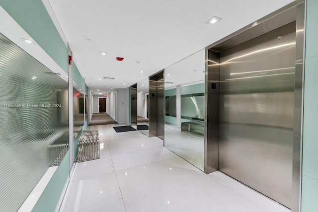 corridor featuring light tile patterned floors and elevator