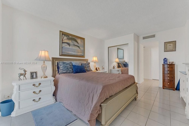 bedroom featuring a textured ceiling and light tile patterned flooring