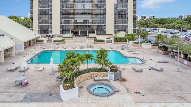 view of swimming pool featuring a patio area and a hot tub