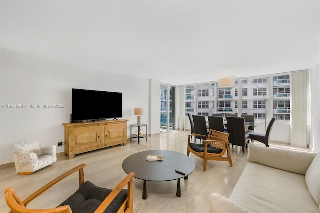 living area featuring light wood-type flooring, plenty of natural light, expansive windows, and baseboards