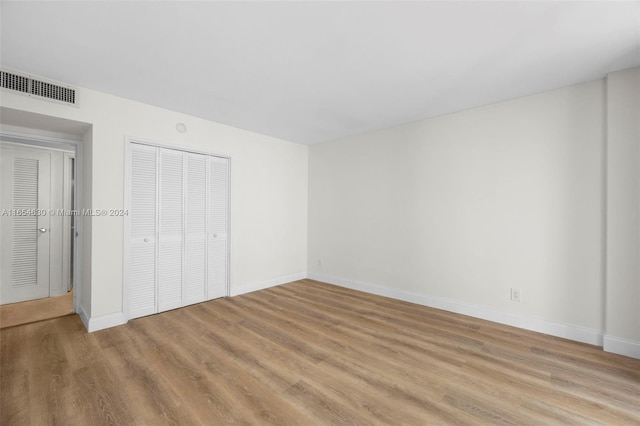 unfurnished bedroom featuring light hardwood / wood-style flooring and a closet