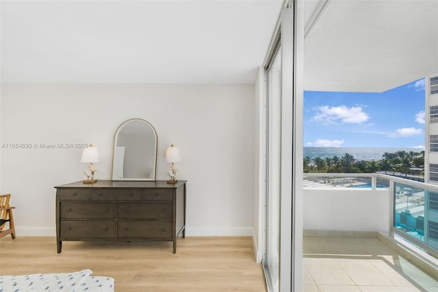 bedroom with light wood-style floors, a closet, and baseboards