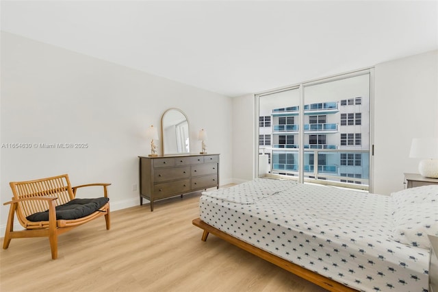 bedroom with light wood-style floors and baseboards