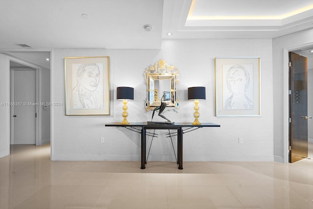 interior space with a tray ceiling and tile patterned floors