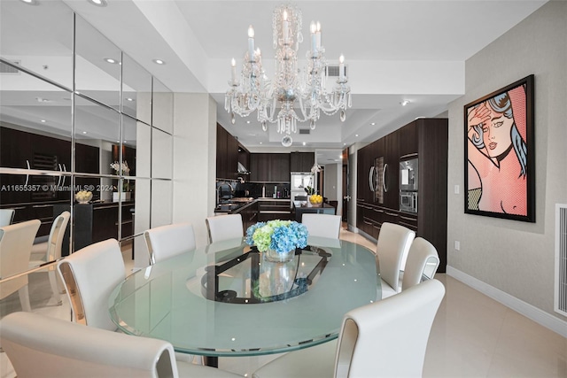 dining space with a raised ceiling, a chandelier, and sink