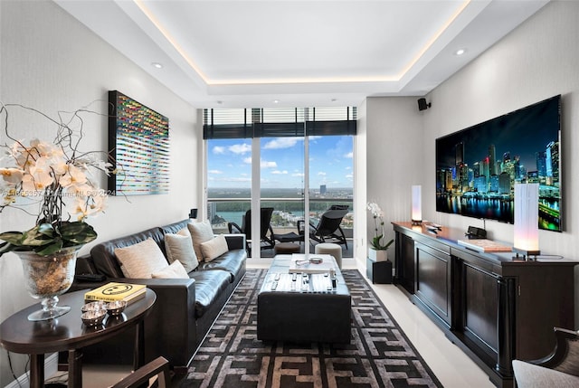 living room featuring a wall of windows and a tray ceiling