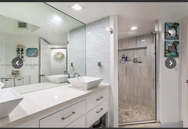 bathroom featuring vanity, tiled bath, and tile patterned floors