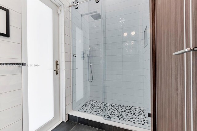 bathroom featuring tiled shower and tile patterned flooring