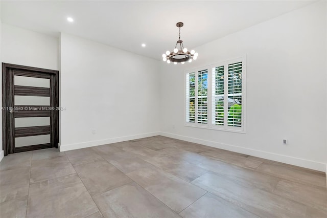 spare room featuring a chandelier