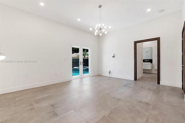 empty room featuring a towering ceiling and a chandelier