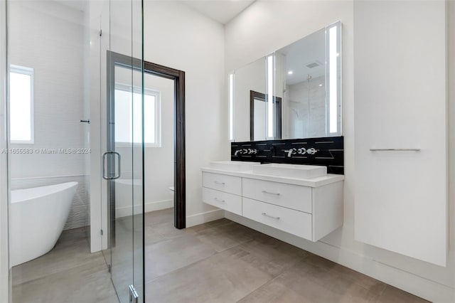 bathroom featuring concrete flooring, a wealth of natural light, shower with separate bathtub, and vanity