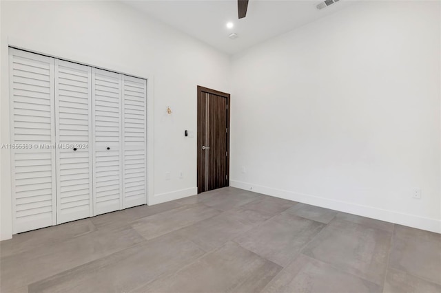 unfurnished bedroom with ceiling fan and a closet