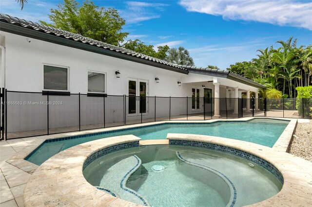 view of swimming pool with an in ground hot tub