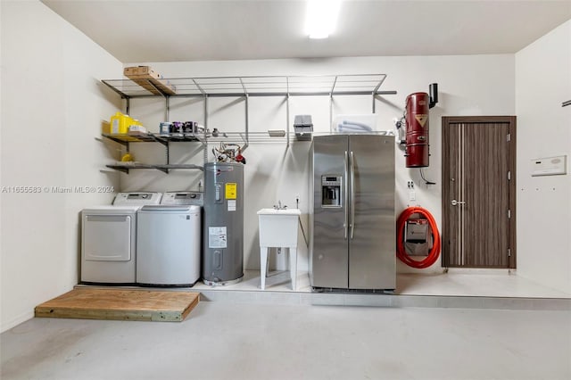 utility room with water heater, washer and clothes dryer, and sink