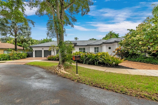 view of front of house with a garage and a front yard