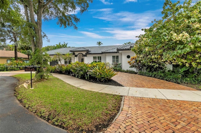 mediterranean / spanish-style home with a front lawn