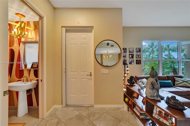 tiled foyer featuring a chandelier