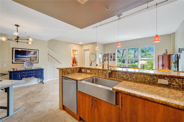 kitchen with pendant lighting, sink, stainless steel dishwasher, and light stone countertops