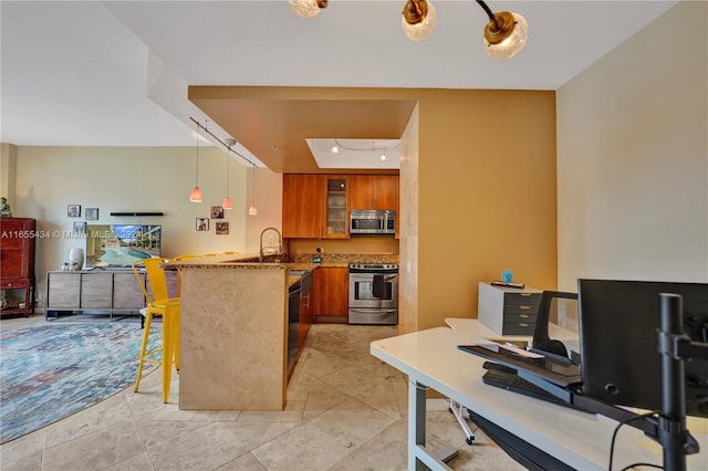 kitchen with kitchen peninsula, appliances with stainless steel finishes, a kitchen bar, stone countertops, and decorative light fixtures