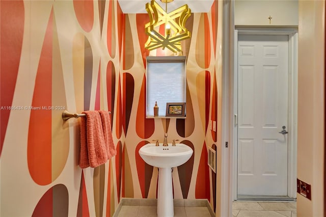 bathroom featuring tile patterned flooring and a chandelier