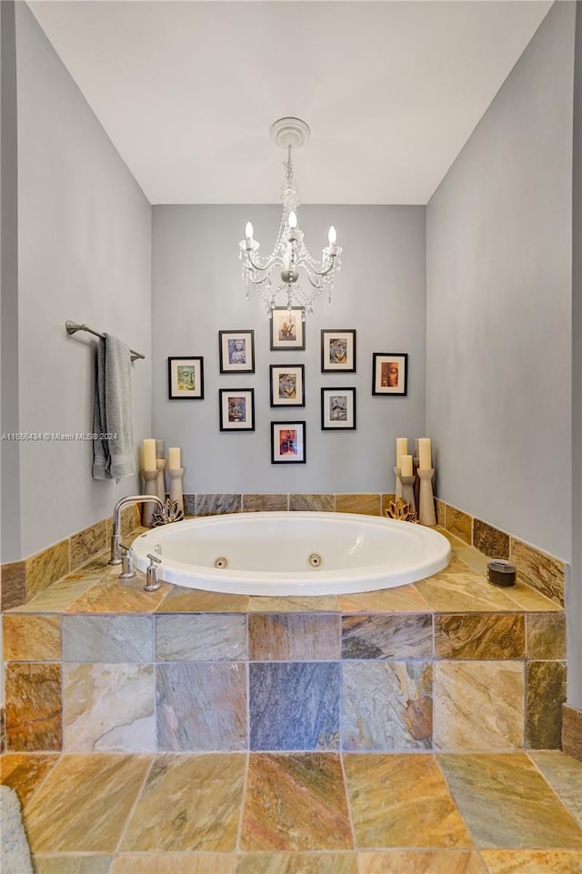 bathroom featuring tiled tub and an inviting chandelier