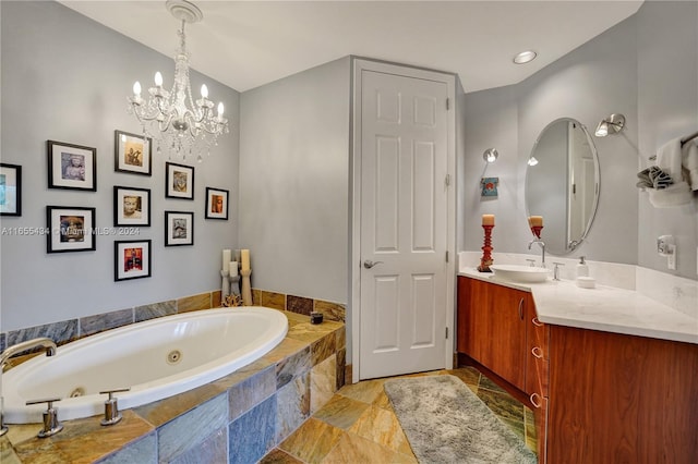 bathroom with tiled tub, vanity, and an inviting chandelier