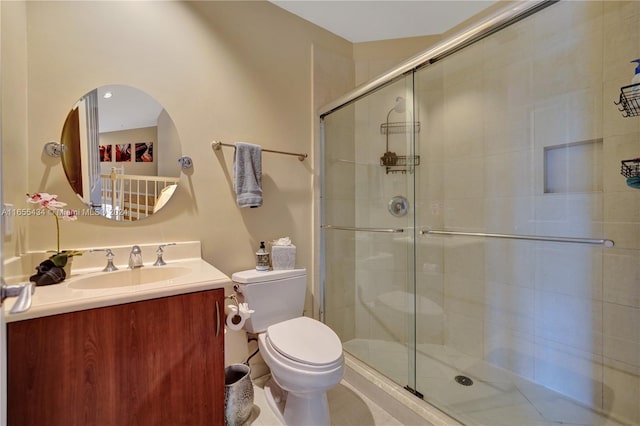 bathroom featuring an enclosed shower, vanity, and toilet