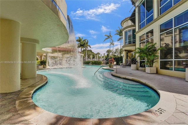 view of swimming pool featuring pool water feature and a patio area