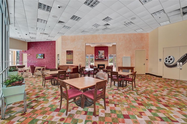 dining room with a drop ceiling and a high ceiling