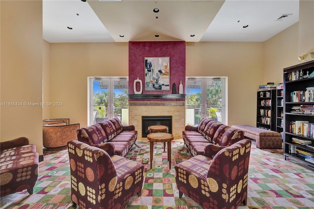 living room featuring a large fireplace, plenty of natural light, and french doors