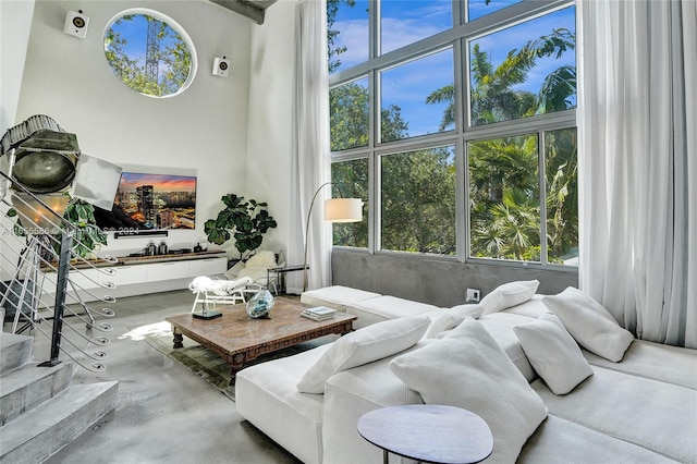 living room featuring concrete floors and a towering ceiling