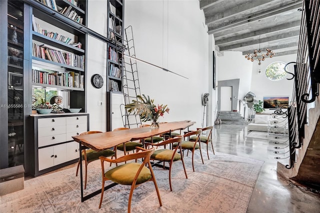 dining area with concrete floors, a high ceiling, and an inviting chandelier