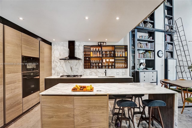 bar featuring stainless steel gas cooktop, decorative backsplash, wall chimney exhaust hood, and sink