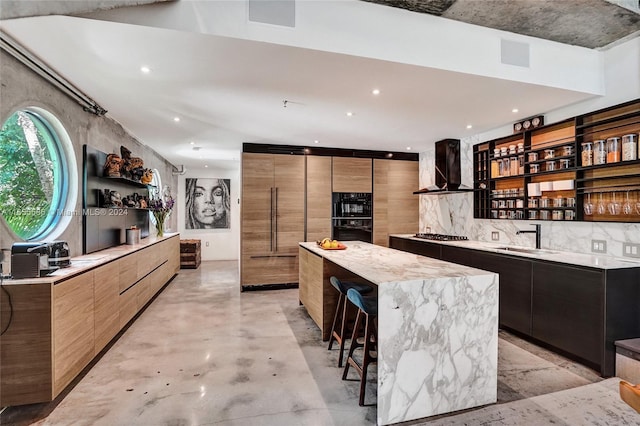 kitchen with a center island, sink, decorative backsplash, wall chimney exhaust hood, and a breakfast bar area