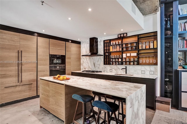 bar featuring wall chimney range hood, stainless steel gas cooktop, tasteful backsplash, and sink