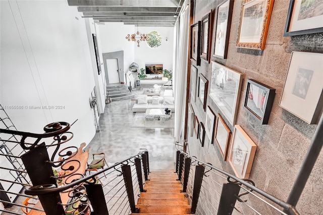 stairway featuring a high ceiling and a chandelier