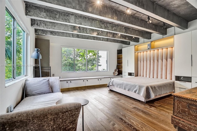 bedroom with beam ceiling, wood-type flooring, and multiple windows