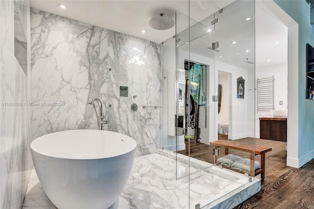 bathroom with tile walls, separate shower and tub, hardwood / wood-style floors, and vanity